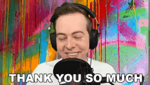 a man wearing headphones is smiling and saying `` thank you so much '' .
