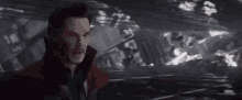 doctor strange is standing in front of a building in a dark room .