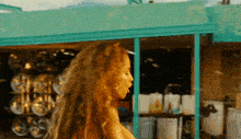 a woman in a bikini is blowing bubbles in front of a green building