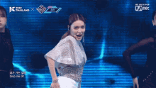 a woman is dancing on a stage with a sign that says we are k pop on it