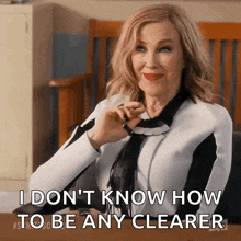a woman is sitting at a desk and says " i don 't know how to be any clearer "