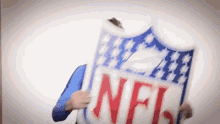 a man is holding a shield with the nfl logo on it .