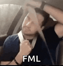a man is sitting in a car wearing a seat belt and making a funny face .