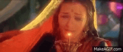 a woman is holding a candle in her mouth and crying .