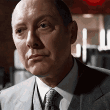 a man wearing a suit and tie looks at the camera