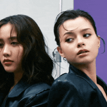 two women are standing next to each other and one is wearing a leather jacket