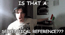a man wearing a shirt that says " is that a serpentical reference " points at something