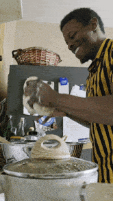 a man in a yellow and black striped shirt prepares food