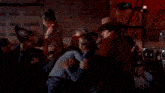 a man in a cowboy hat stands behind a bar