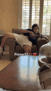 a man sitting on a couch with a broken heart and the words prime written on the floor