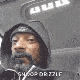 snoop dogg is wearing a hoodie and beanie in a car .