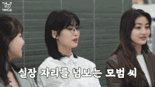 a woman wearing glasses sits next to two other women with twice written in the corner