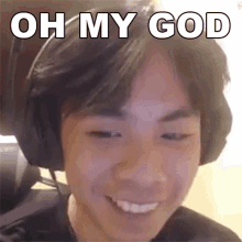 a young man wearing headphones is smiling and says oh my god