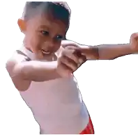 a young boy wearing a white tank top and red shorts is pointing at something
