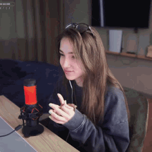 a woman sitting in front of a red and black microphone with a popup that says ' 00 000 rub ' on it