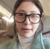 a close up of a woman wearing glasses and a green coat