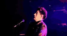 a man is singing into a microphone on stage .