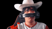 a man wearing a cowboy hat and headphones making a face