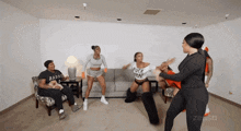 a group of women are dancing in a living room with one wearing a shirt that says " fuck that "