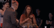 a woman is talking to a man while holding a cup of fireballs