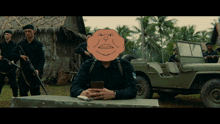 a man sitting at a table with a cartoon face on his head