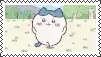 a white cat with a blue bow on its head is standing in a field .