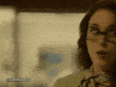 a woman wearing glasses and a scarf has the hashtag lialmeida05 on the bottom
