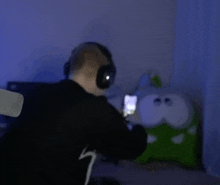 a man wearing headphones is looking at a cell phone