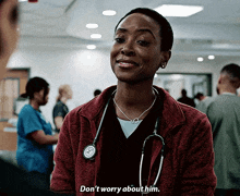 a woman with a stethoscope around her neck is smiling and says " don 't worry about him "