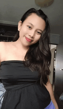 a woman in a black strapless top is smiling