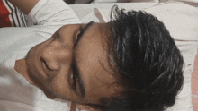 a close up of a man 's face with a white shirt on