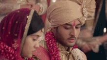 a bride and groom are sitting next to each other and the groom has a red mark on his forehead