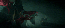 a person wearing red gloves is holding a pair of scissors in their hand
