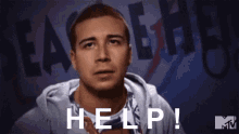 a man in a hoodie says help in front of a sign that says team eh