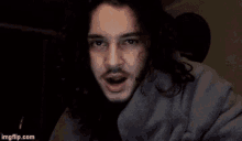 a man with long hair and a beard smiles for the camera with imgflip.com in the corner