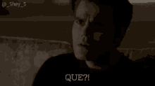 a man is sitting on a couch and making a funny face while talking to someone .
