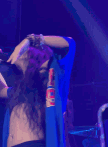 a woman is singing into a microphone while wearing a blue shirt that says ' sea ' on it