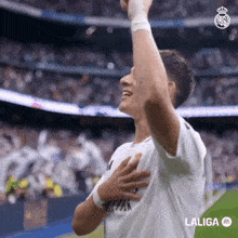 a soccer player celebrates a goal with his hands in the air sponsored by laliga