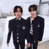 two young men are standing next to each other in a room .