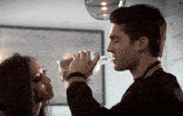 a man is pouring a drink into a woman 's glass
