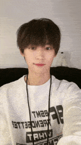 a young man taking a selfie with a white shirt that says tahvo on it