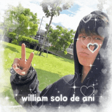 a boy in a hoodie giving a peace sign with the words " william solo de ani " below him