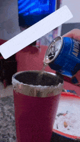 a person is pouring a can of antarctica into a pink cup