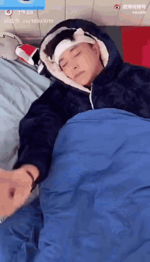 a man with a bandage on his head is laying in a blue sleeping bag