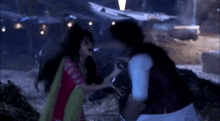 a man and a woman are fighting in the dark .
