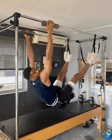 a man is doing exercises on a pilates machine in a gym
