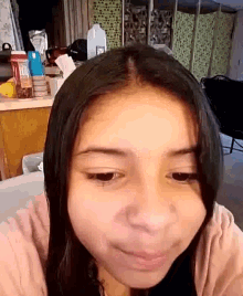 a woman 's face is shown in front of a kitchen counter with a bottle of milk on it