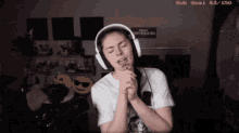 a woman wearing headphones has a sub goal of 53/150 on the screen