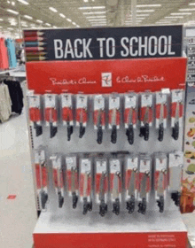 a display of knives and scissors in a store with a sign that says back to school