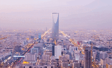 an aerial view of a city with a very tall building in the middle